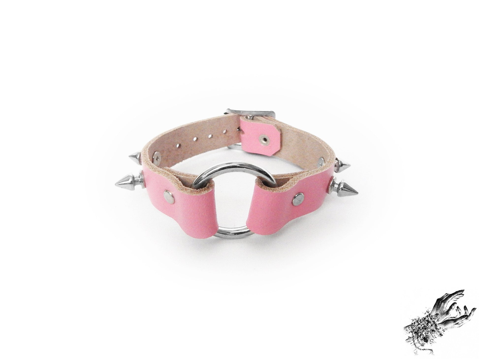 Pink leather wristband featuring a central silver O ring and bold 13mm spike studs, made in the UK for pastel goth and kawaii fashion
