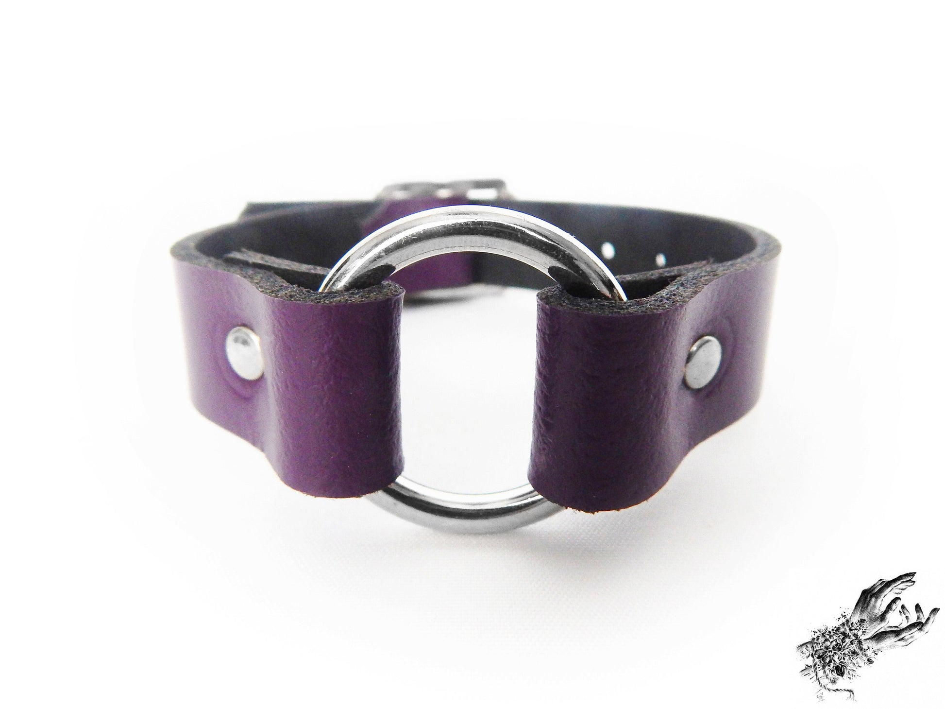 Close-up of the purple leather O ring wristband, showing the central silver O ring and durable silver rivets on a white background