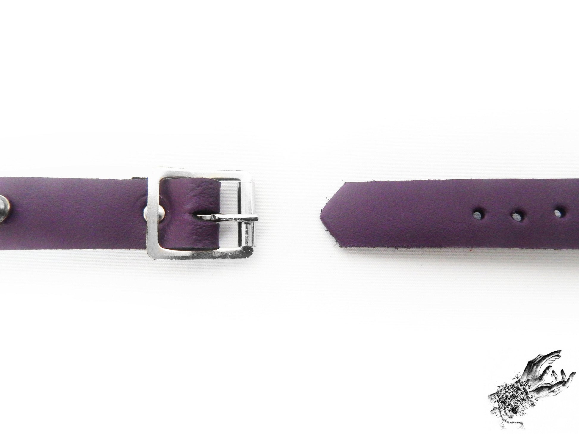 Close-up of the buckle on the purple studded o ring wristband, showing the stainless steel plated buckle and adjustable holes for versatile sizing