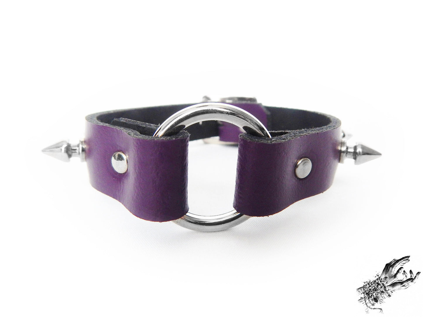 Close-up of the purple studded o ring wristband, showing the central silver O ring, bold 13mm spike studs and durable silver rivets
