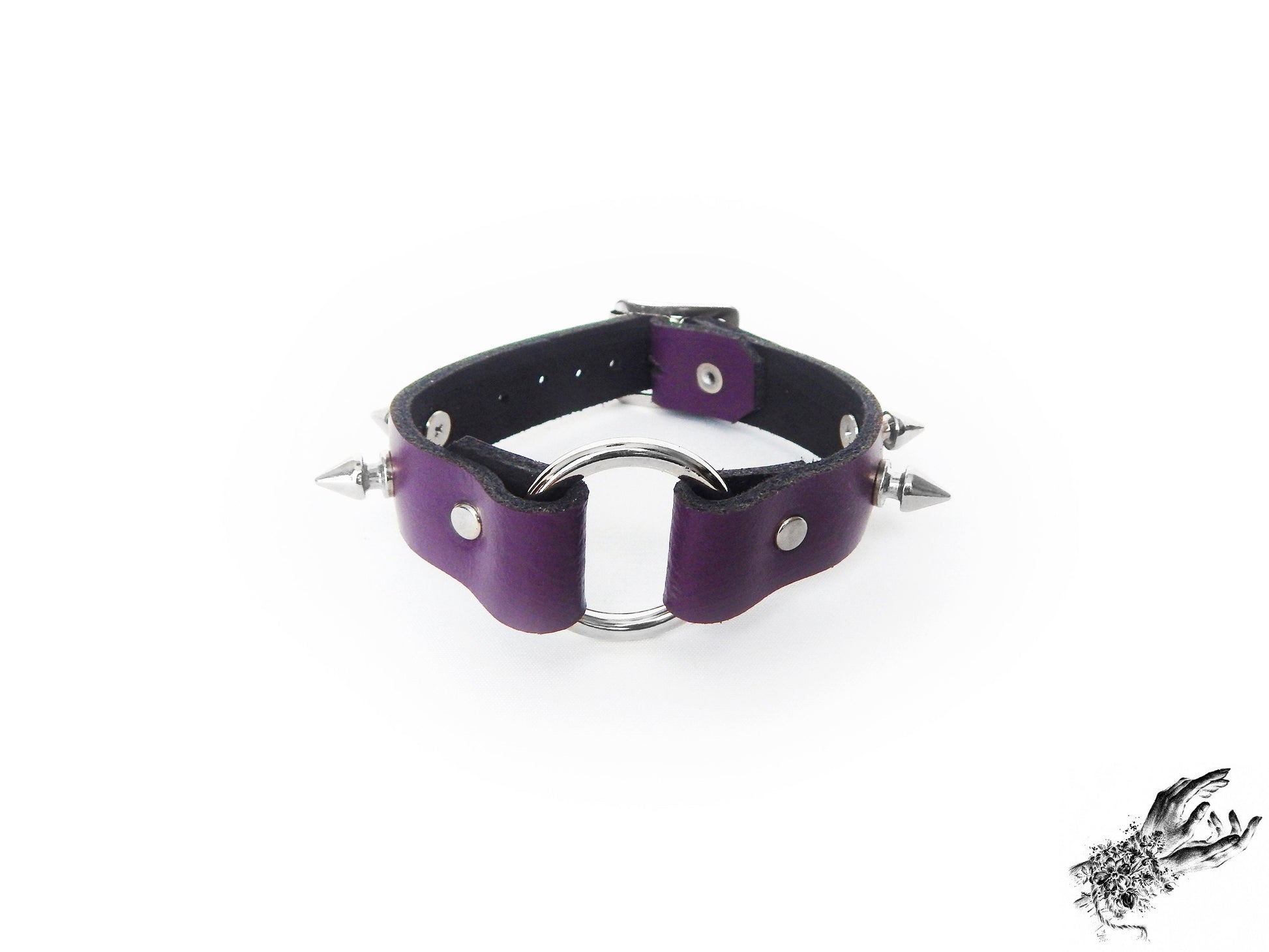 Purple leather wristband featuring a central silver O ring and bold 13mm spike studs on a white background