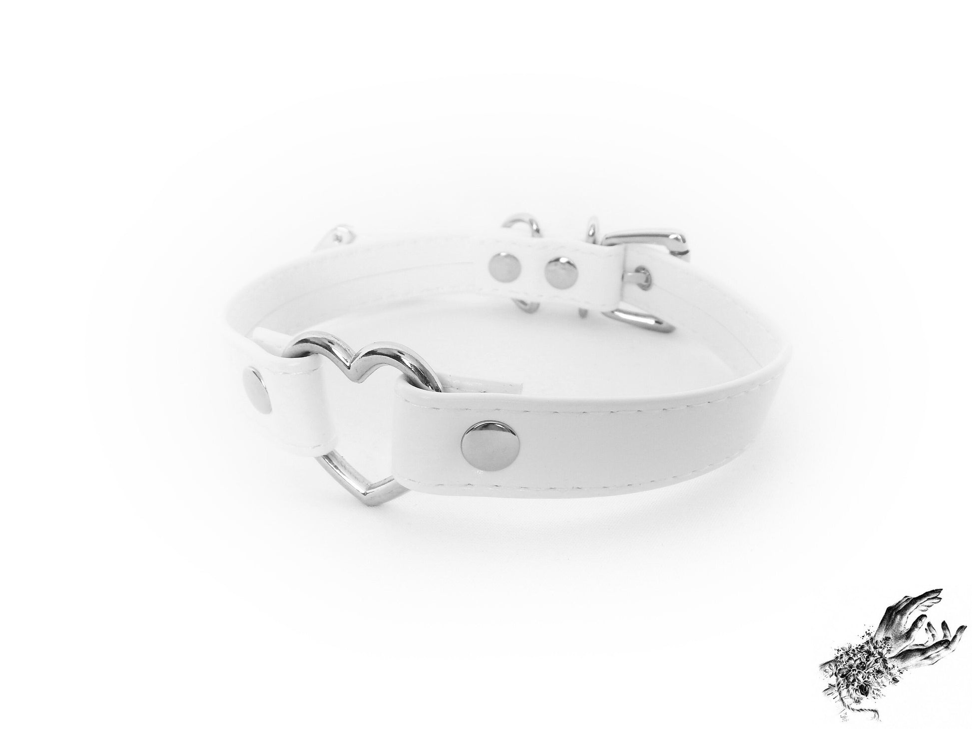 White faux leather choker featuring a central silver heart ring and stainless steel plated hardware, with adjustable buckle and sizing holes at the back. Displayed on a white background.