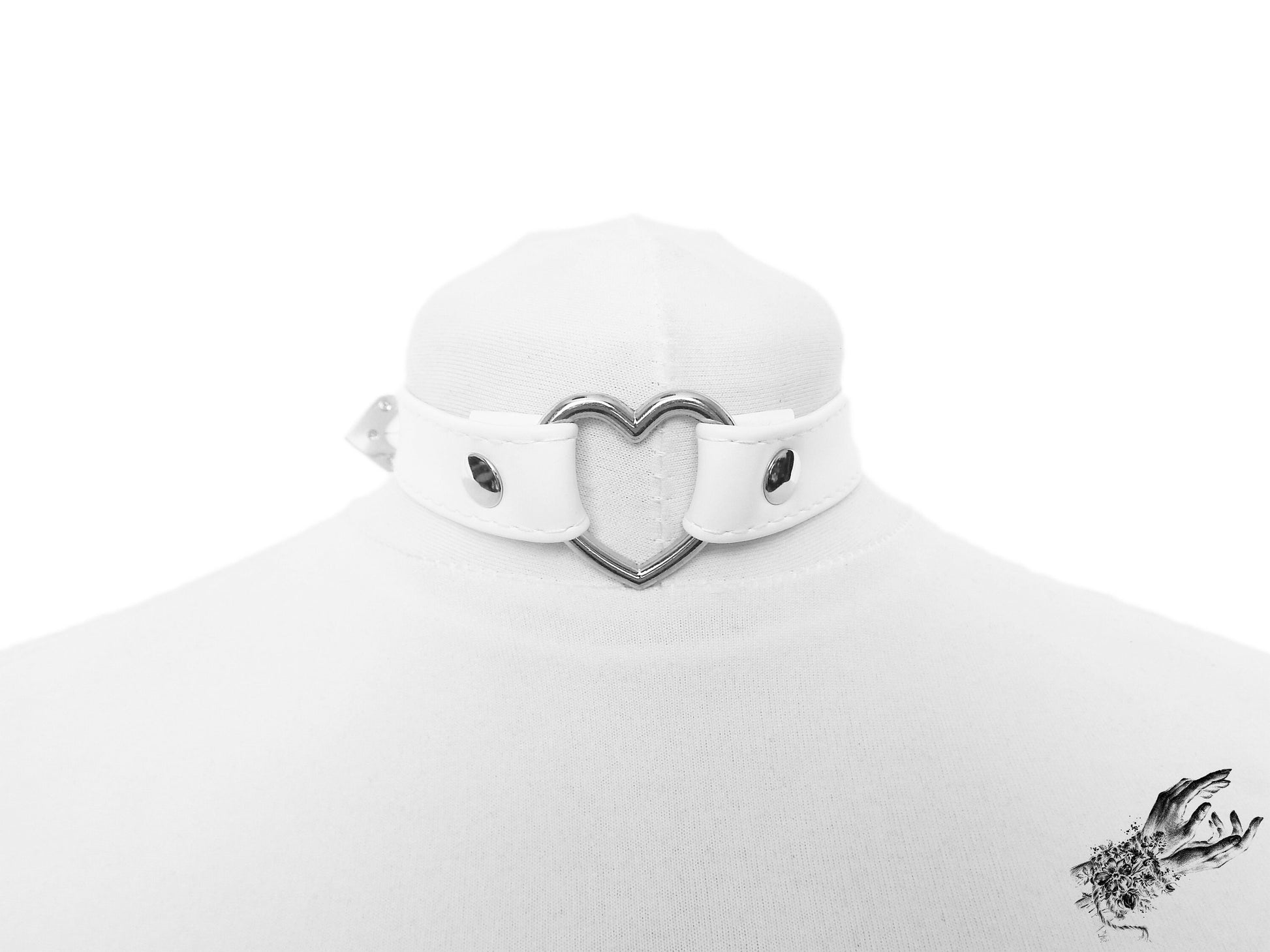 White faux leather choker featuring a central silver heart ring and stainless steel plated hardware, with adjustable buckle and sizing holes at the back. Displayed on a cream mannequin bust against a white background.