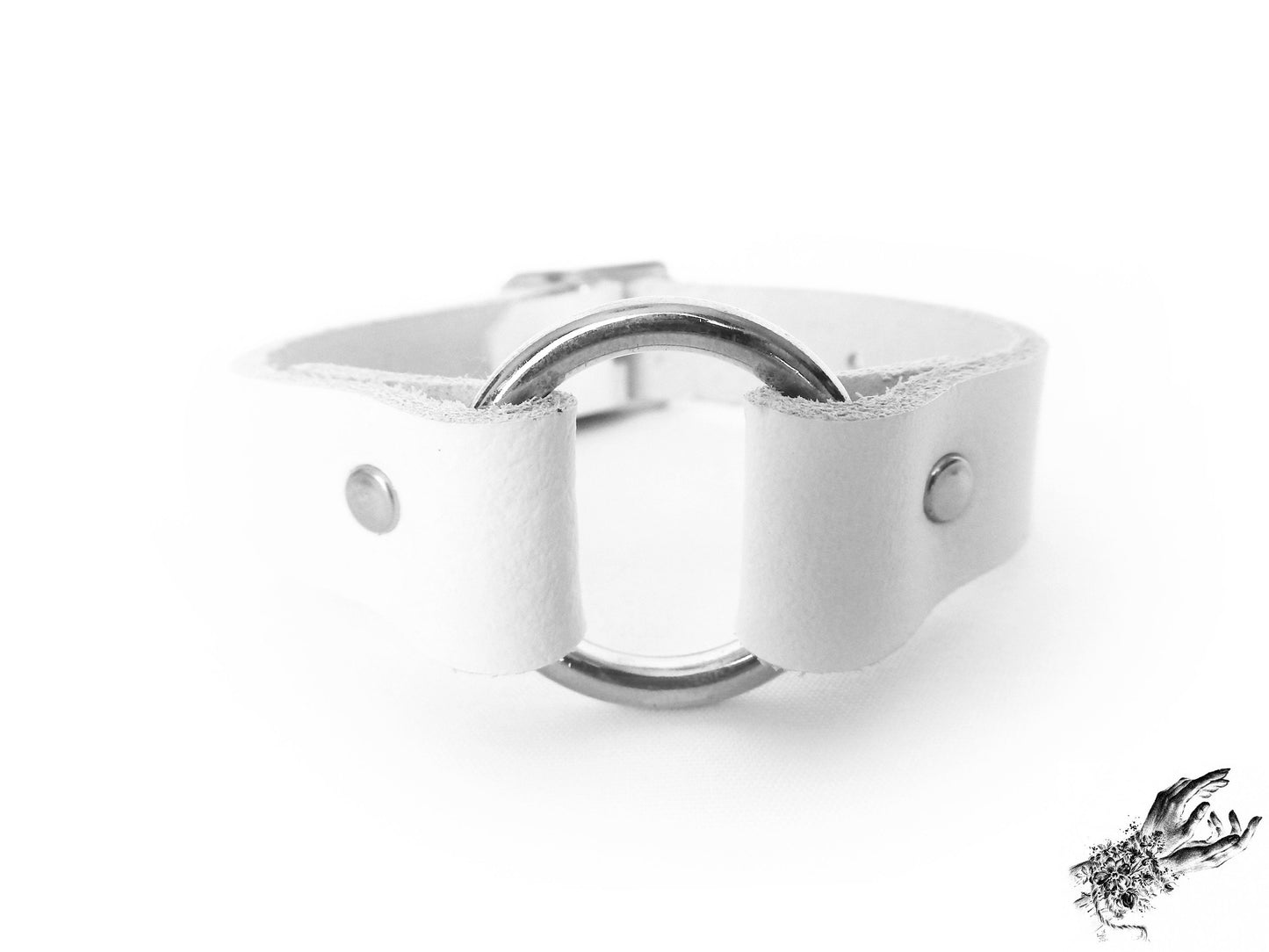 Close-up of the white leather O ring wristband, showing the central silver O ring and durable silver rivets, made for pastel goth and alt fashion in the UK