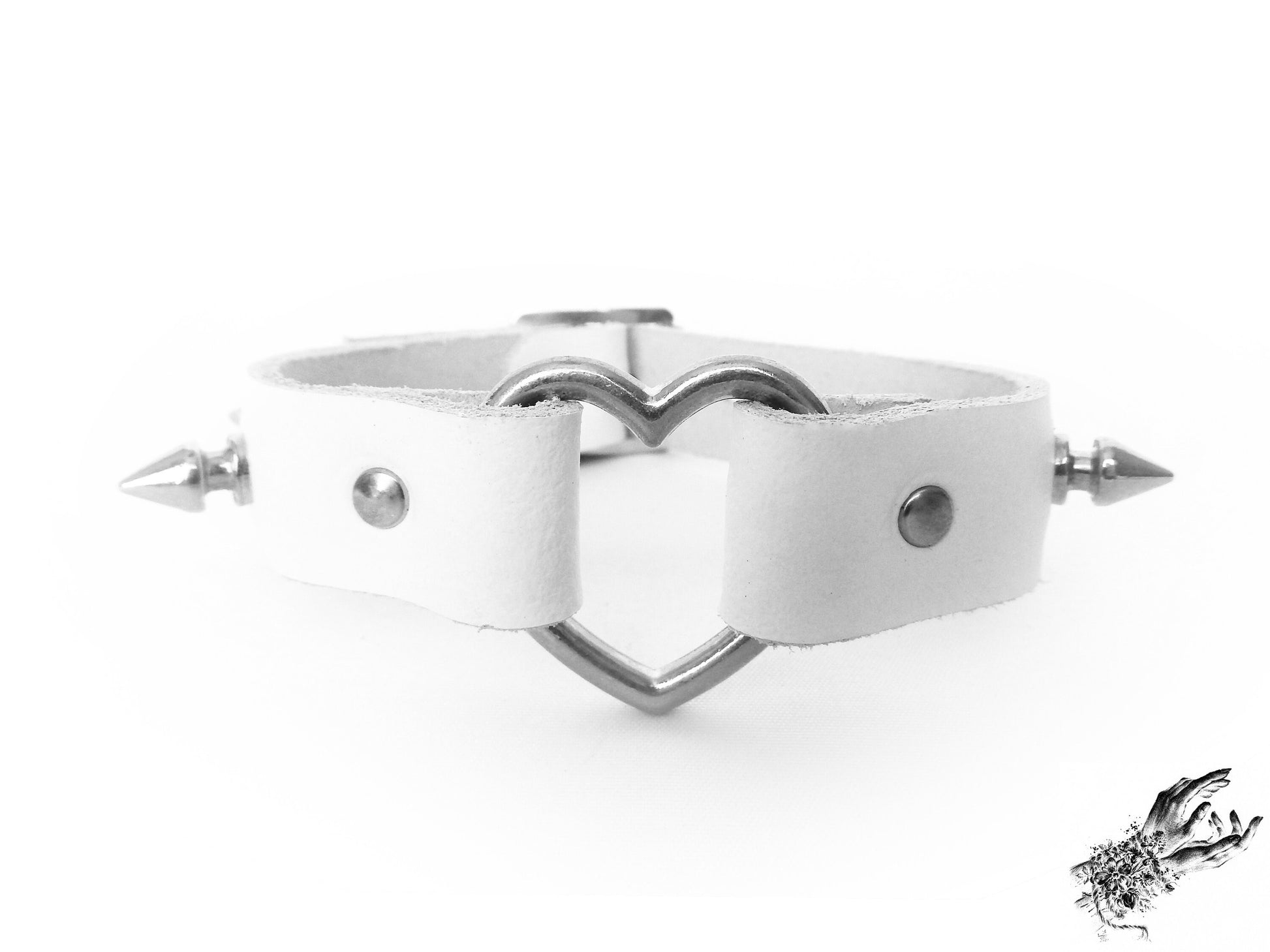 Close-up of the white studded heart ring wristband, showing the silver heart ring, durable silver rivets and spike studs