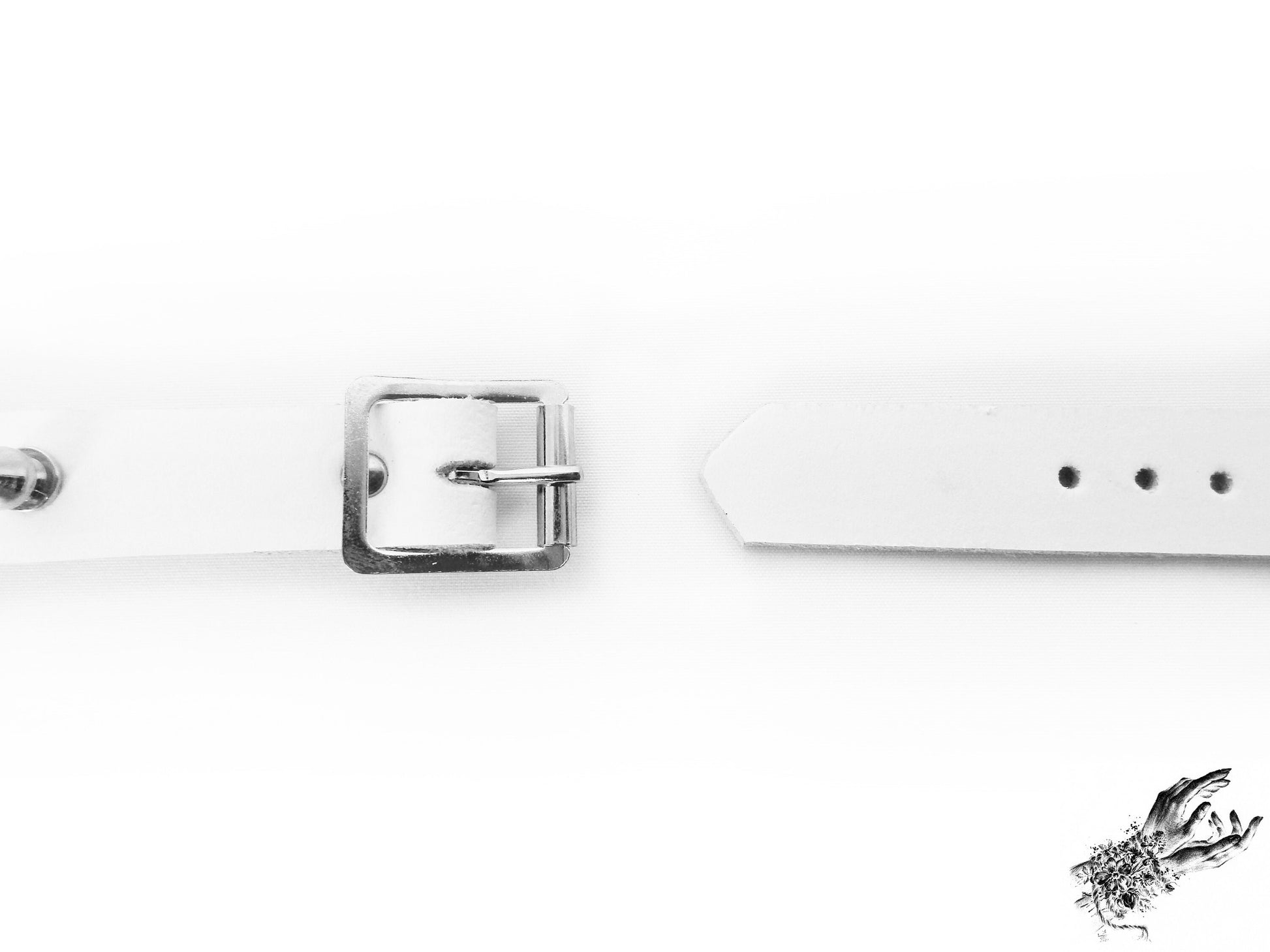Close-up of the buckle on the white studded o ring wristband, showing the stainless steel plated buckle and adjustable holes for versatile sizing