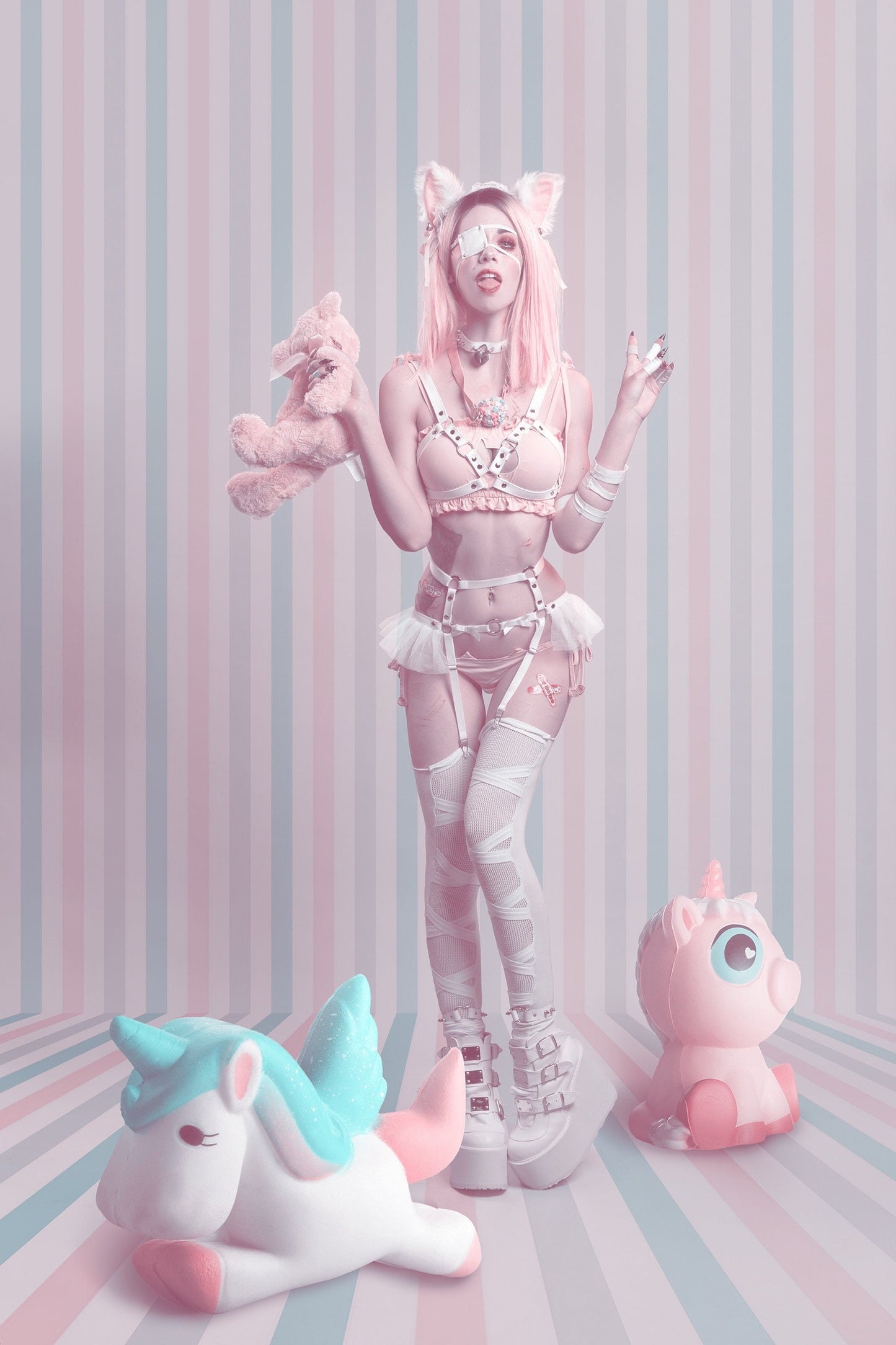 Modelled photo of a white vegan leather harness set featuring silver O ring hardware, ruffled tulle accents and bow appliques at the waist, styled with pastel pink lingerie and white thigh high stockings for a pastel goth look.